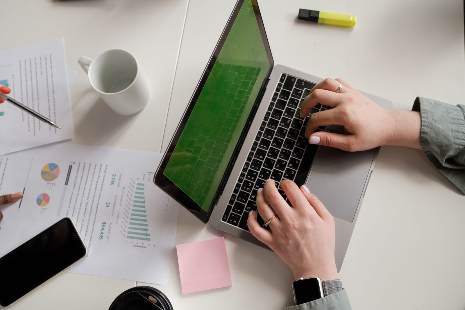 Notes, charts and a laptop on a desk
